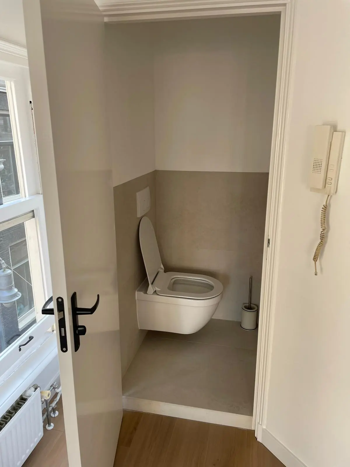 Kleine toiletruimte met een hangend toilet, gezien vanuit een open deur in een woning aan de Korte Kolksteeg.